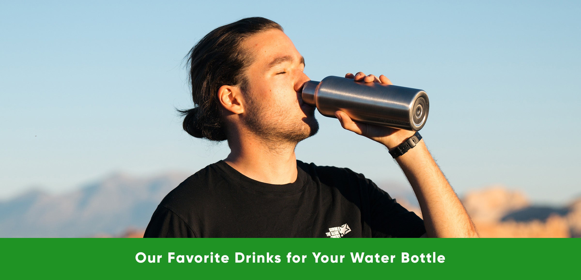 A guy drinking from the Blockhuette vacuum insulated stainless steel water bottle