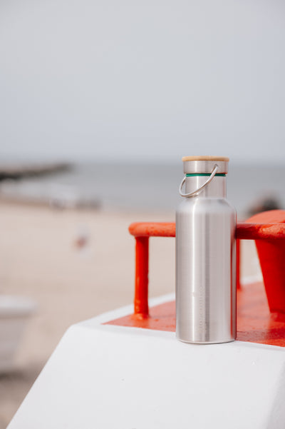 Blockhuette stainless steel water bottle standing on a beach