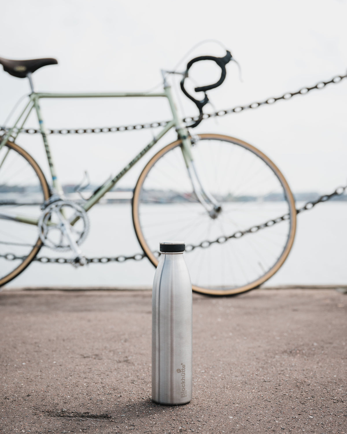 Blockhuette double vacuum insulated stainless steel water bottle standing in front of a bicycle