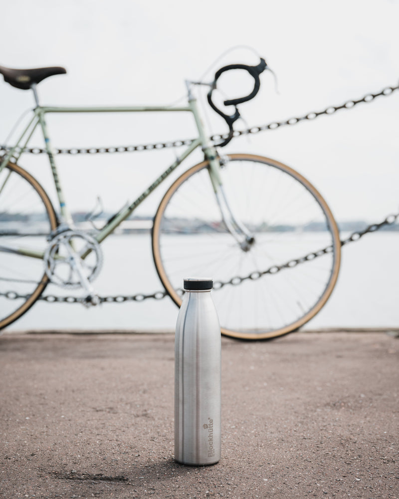 Blockhuette double vacuum insulated stainless steel water bottle standing in front of a bicycle