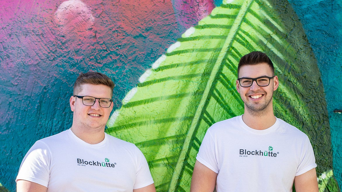 Malte and Nils, the founders of Blockhütte, in front of a painted wall