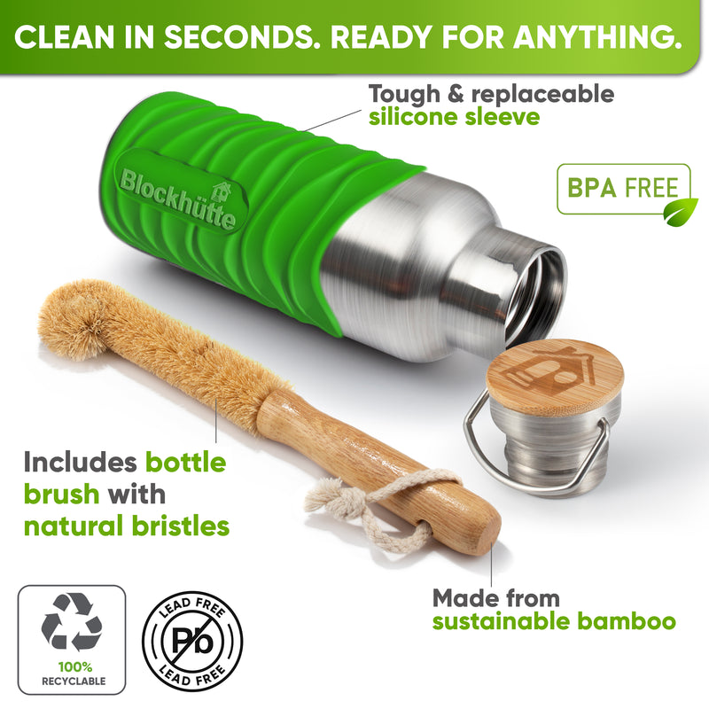 Bottle in a bright green silicone sleeve lying on its side next to a bamboo bottle brush with natural bristles and the bamboo cap