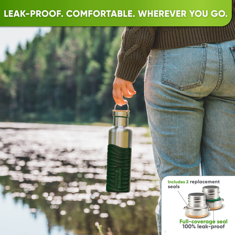 Person in jeans and a knit sweater by a lake, carrying the 25 oz bottle in a dark green silicone sleeve by the cap handle; inset: caps with replacement seals