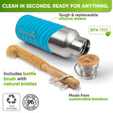 Bottle in a turquoise silicone sleeve lying on its side next to a bamboo bottle brush with natural bristles and the bamboo cap