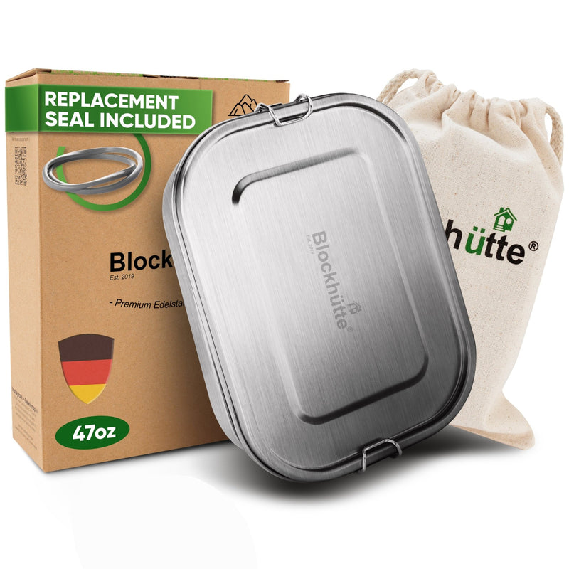 Stainless steel lunch box, 47 oz, closed, leaning against a cotton drawstring bag with Blockhutte logo