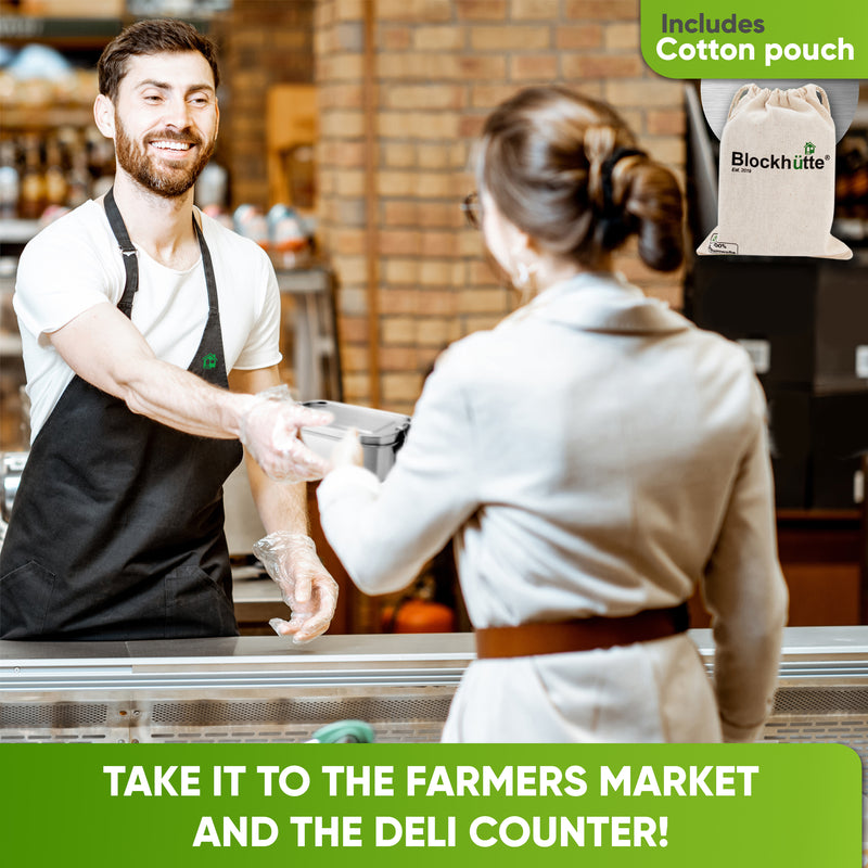 Deli clerk handing a closed stainless steel lunch box across the counter to a smiling customer; cotton pouch included